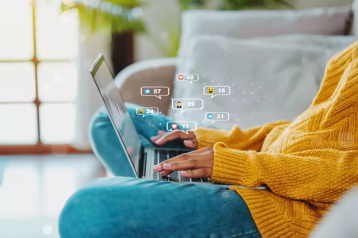 Entrepreneur·e tapant sur un ordinateur avec rĂ©actions sociales â solution clĂ©s en main pour rĂ©seaux sociaux